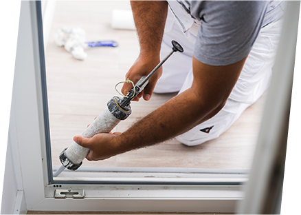 A man repairs a door, addressing air leaks to enhance energy efficiency around doors and windows.